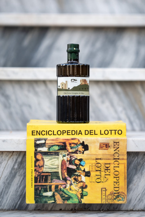 La bottiglia Tenuta Grieci su un libro giallo, su gradini di marmo